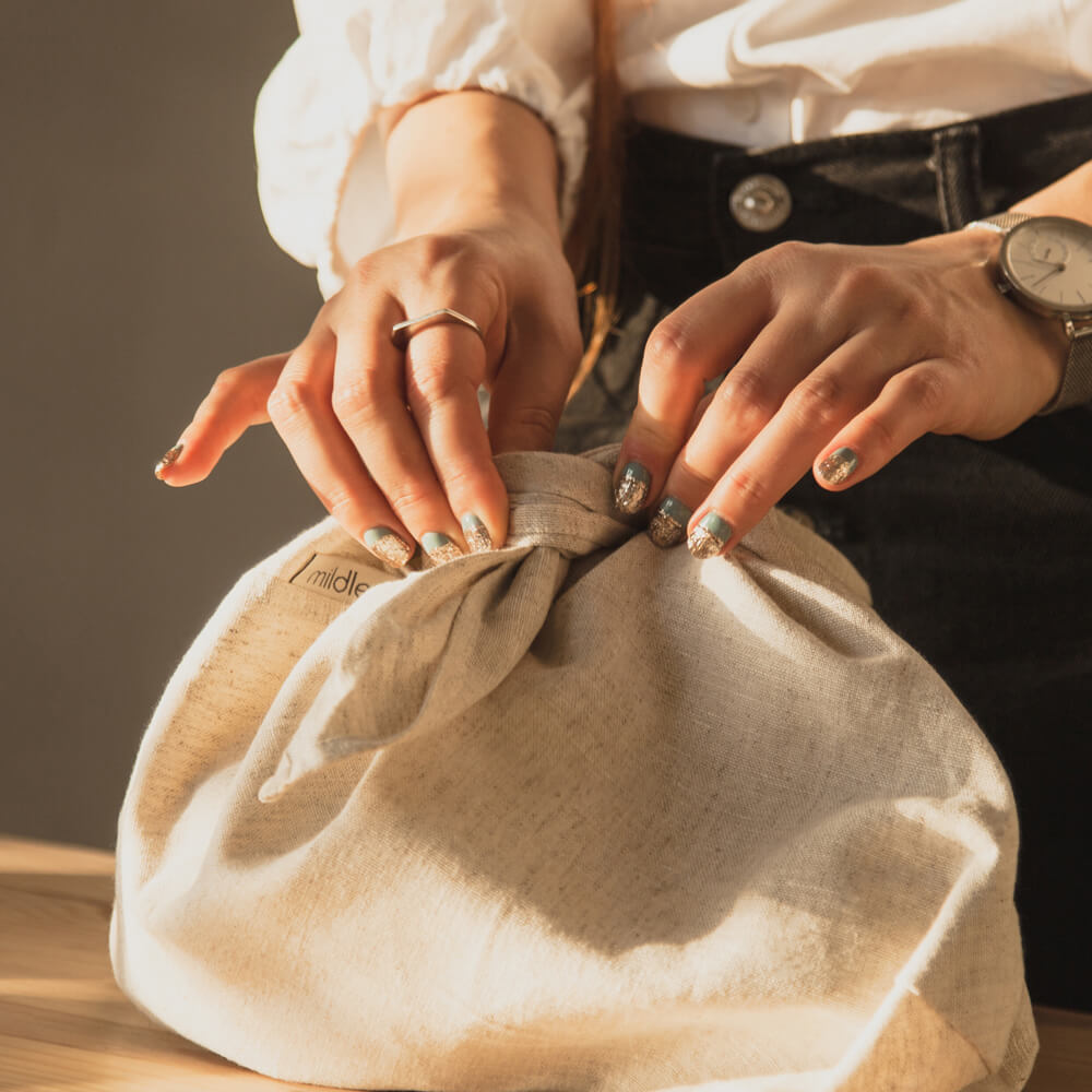 Two Hands Untying the Linen Bread Bento Bag